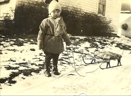 old photo of child with sled